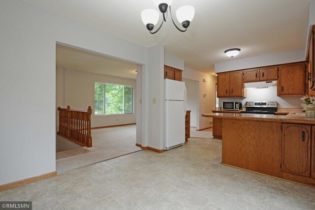 kitchen featuring a notable chandelier, appliances with stainless steel finishes, kitchen peninsula, and a textured ceiling