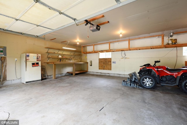 garage with a garage door opener and white fridge