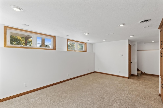 empty room with light carpet and a textured ceiling