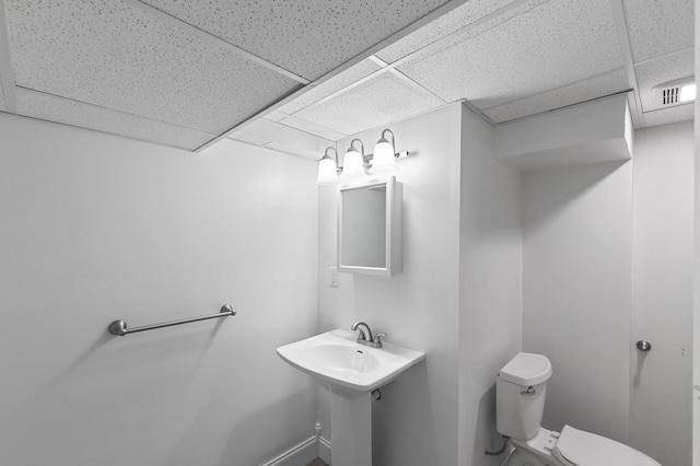 bathroom featuring toilet and a drop ceiling