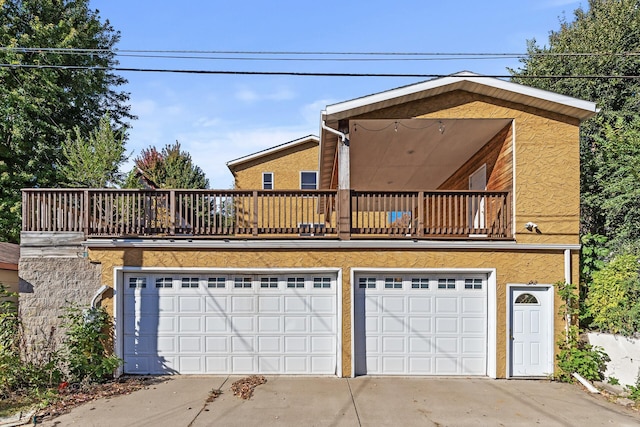 view of front of property featuring a balcony and a garage