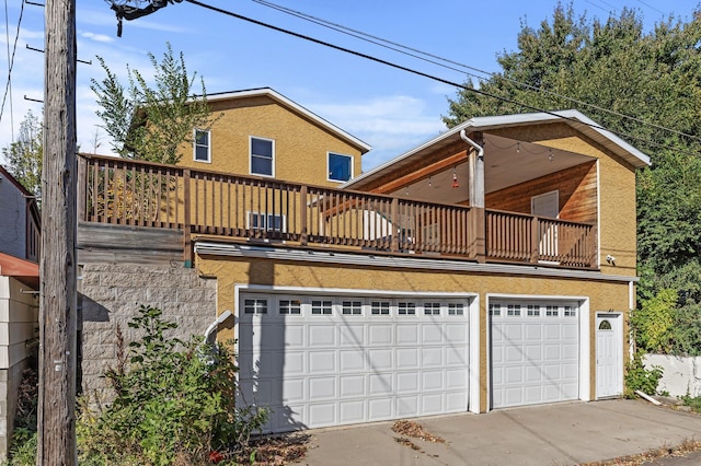 back of property featuring a balcony and a garage