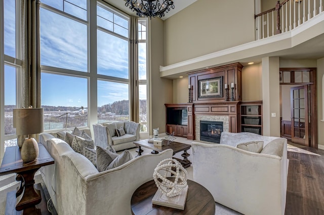 living room featuring a high ceiling, a fireplace, and plenty of natural light