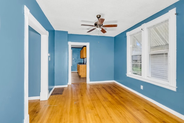 spare room with ceiling fan and wood-type flooring