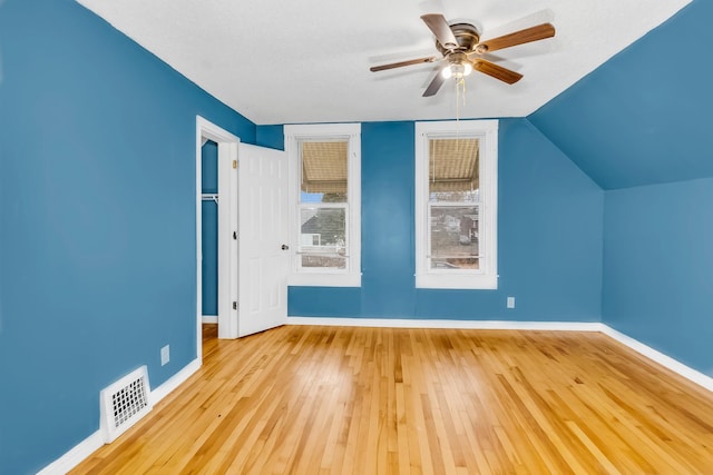 bonus room with ceiling fan, lofted ceiling, a textured ceiling, and light wood-type flooring