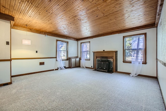 unfurnished living room featuring wood ceiling, carpet flooring, and plenty of natural light