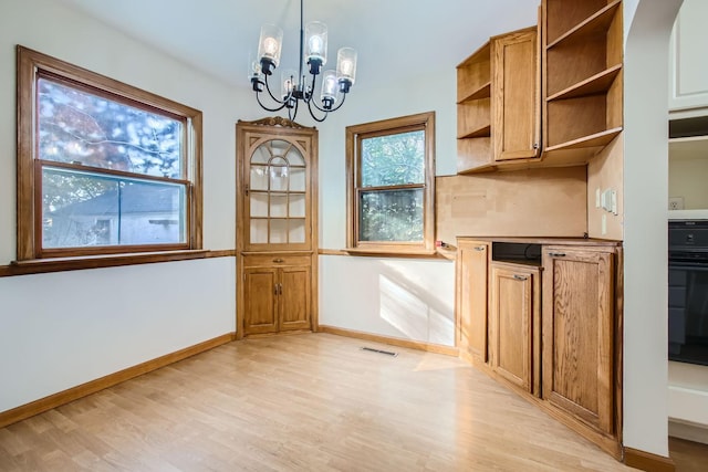 kitchen featuring a notable chandelier, decorative light fixtures, and light hardwood / wood-style floors