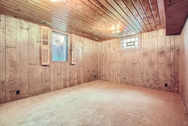 empty room featuring wooden walls, wood ceiling, and carpet floors