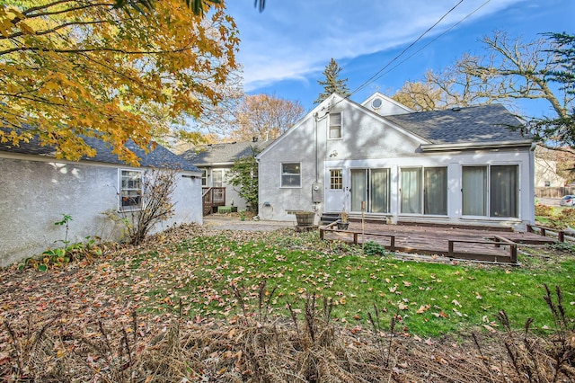 rear view of property with a patio, a wooden deck, and a lawn