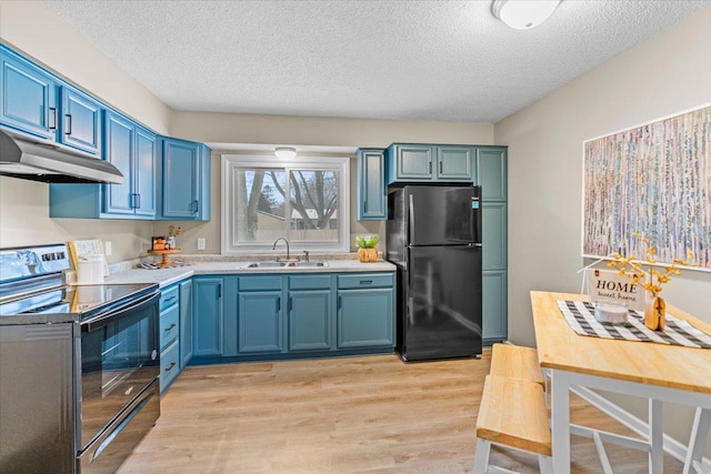 kitchen with under cabinet range hood, a sink, light countertops, blue cabinetry, and black appliances