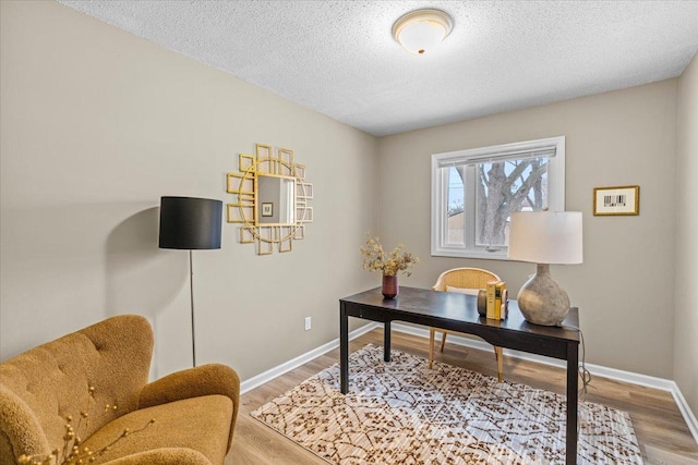 office with a textured ceiling, baseboards, and wood finished floors