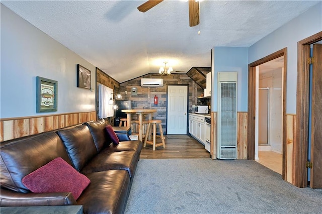 living room featuring ceiling fan, a textured ceiling, wooden walls, and a wall mounted air conditioner