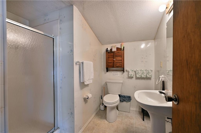 bathroom with a textured ceiling, a shower with shower door, and toilet