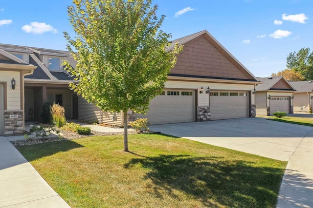 craftsman inspired home featuring a garage and a front yard