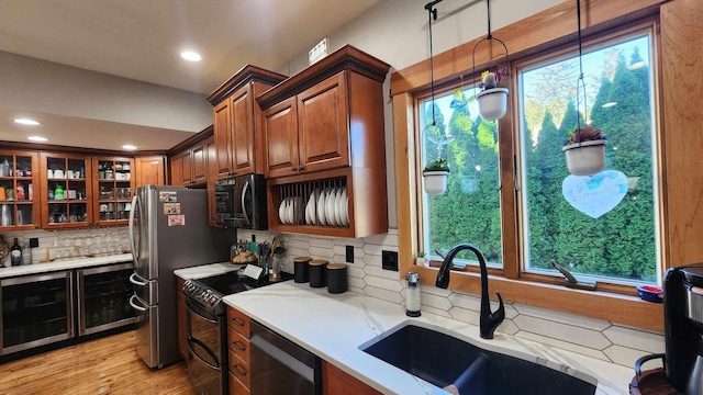 kitchen featuring a healthy amount of sunlight, black appliances, and hanging light fixtures