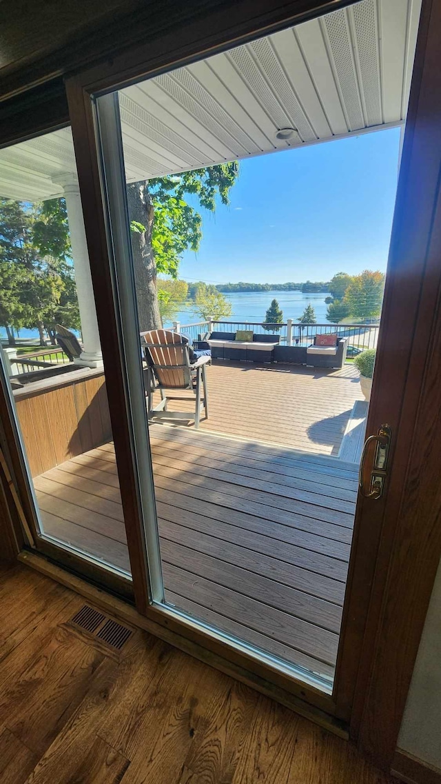 doorway with a water view and dark wood-type flooring