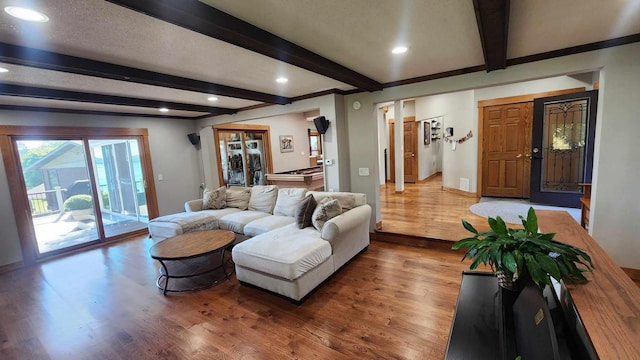 living room with beam ceiling, a textured ceiling, and hardwood / wood-style floors