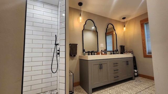 bathroom with tile patterned floors, vanity, and tiled shower