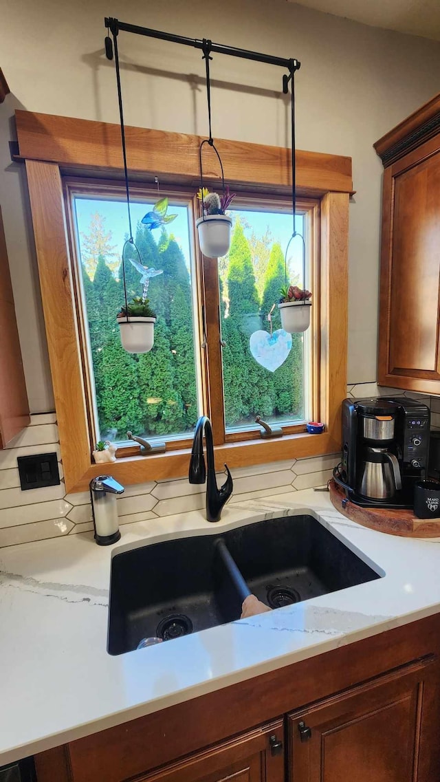 kitchen featuring decorative light fixtures, sink, and tasteful backsplash