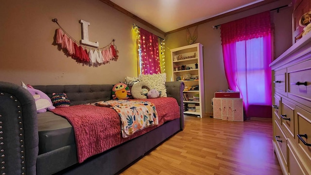 bedroom with light wood-type flooring and crown molding