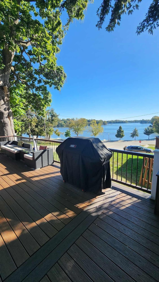 wooden deck with a water view and grilling area