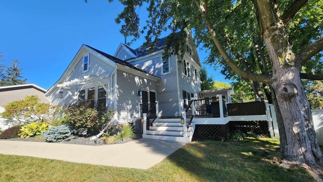 view of side of property featuring a deck and a yard