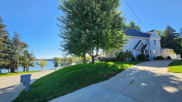 view of side of home featuring a water view and a yard