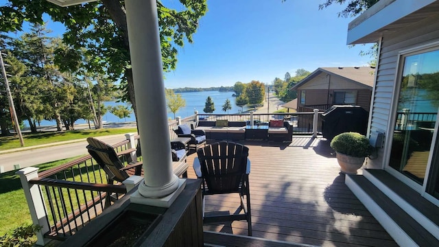 deck featuring outdoor lounge area and a water view