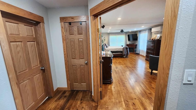 hallway with light hardwood / wood-style flooring and a wall mounted air conditioner