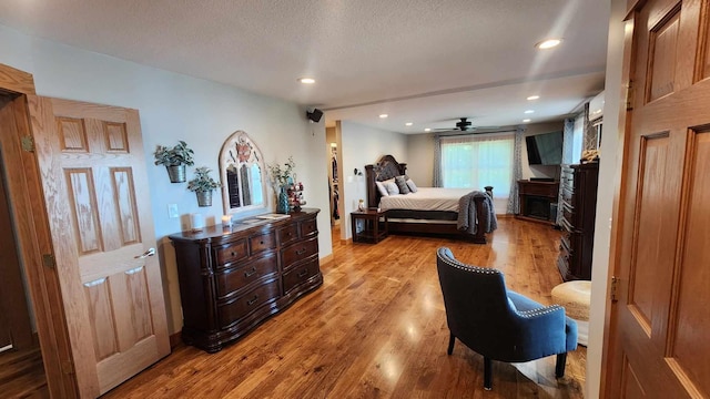 bedroom with light hardwood / wood-style floors and a textured ceiling