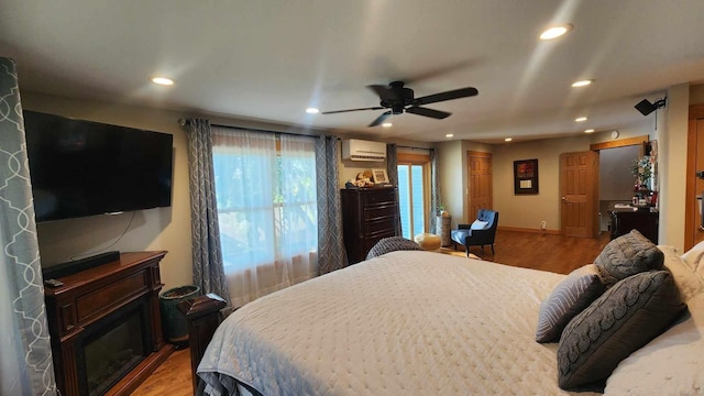 bedroom featuring wood-type flooring, a wall mounted air conditioner, and ceiling fan