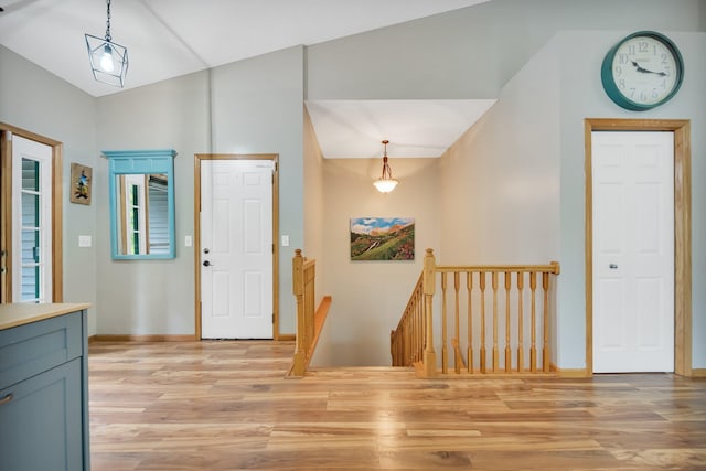 foyer entrance with light hardwood / wood-style flooring and vaulted ceiling