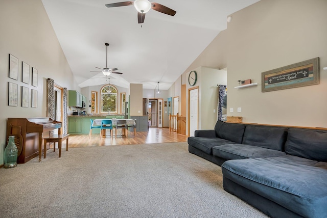 living room with ceiling fan, light hardwood / wood-style floors, and high vaulted ceiling