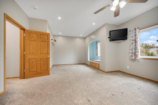 unfurnished living room featuring ceiling fan, light colored carpet, and lofted ceiling