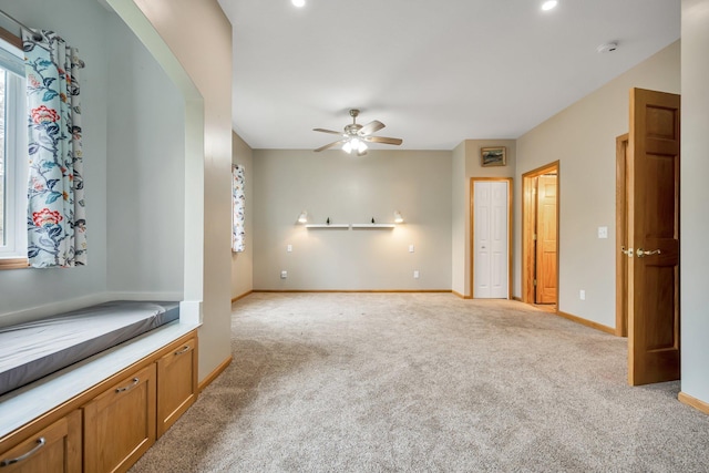 unfurnished living room featuring light colored carpet and ceiling fan