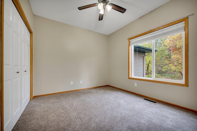 unfurnished bedroom featuring ceiling fan, a closet, and carpet