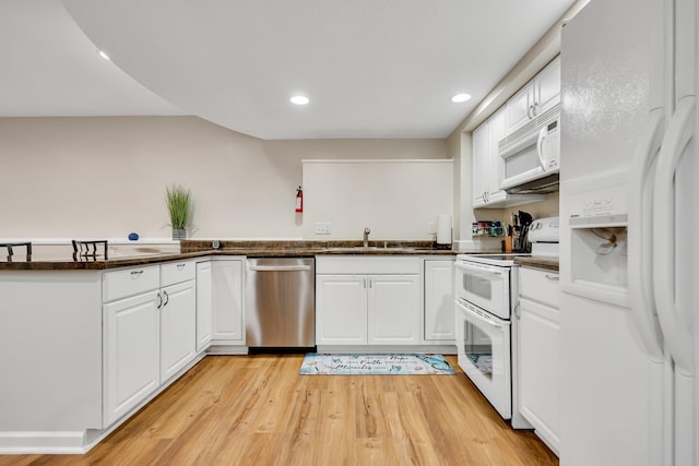 kitchen with white cabinets, light hardwood / wood-style floors, white appliances, and sink