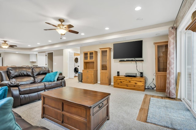 carpeted living room featuring ceiling fan and stacked washer and clothes dryer