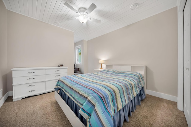 carpeted bedroom with ceiling fan, wood ceiling, and a closet