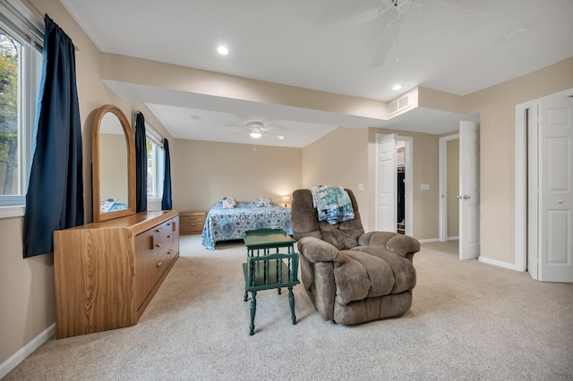 carpeted bedroom with multiple windows, a spacious closet, and ceiling fan