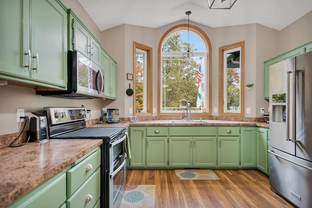 kitchen featuring appliances with stainless steel finishes, light hardwood / wood-style flooring, green cabinetry, and sink