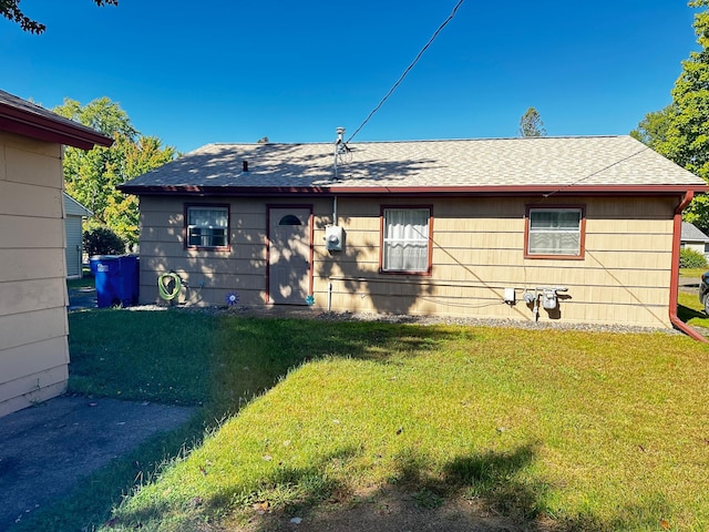 rear view of property featuring a lawn