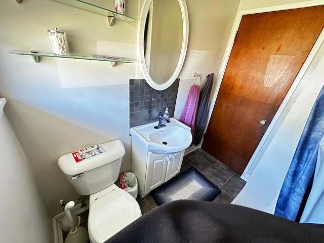 bathroom with vanity, backsplash, and toilet