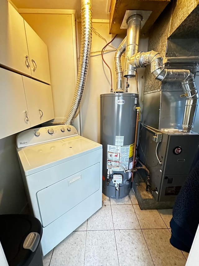 clothes washing area with cabinets, washer / clothes dryer, gas water heater, and light tile patterned floors