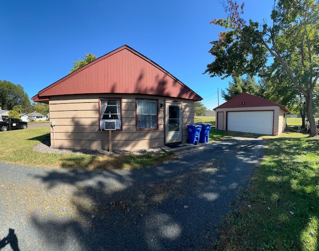 view of front of home with cooling unit, a front yard, an outdoor structure, and a garage