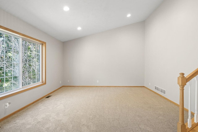 carpeted spare room with lofted ceiling