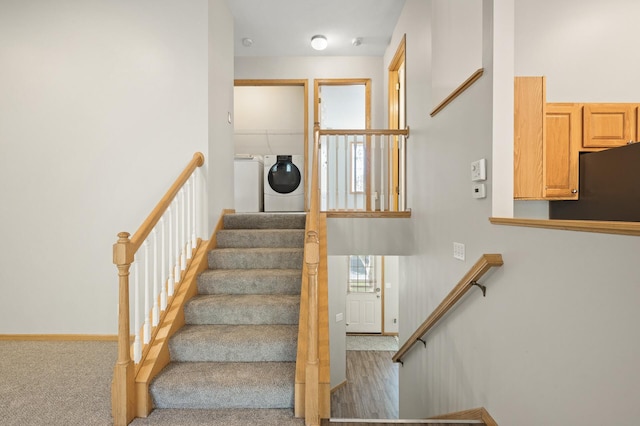 stairs featuring washer and dryer and hardwood / wood-style flooring