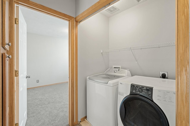 laundry area with separate washer and dryer and light colored carpet