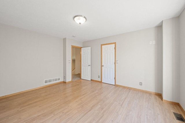 empty room with light hardwood / wood-style flooring