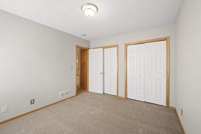 unfurnished bedroom with carpet floors and multiple closets